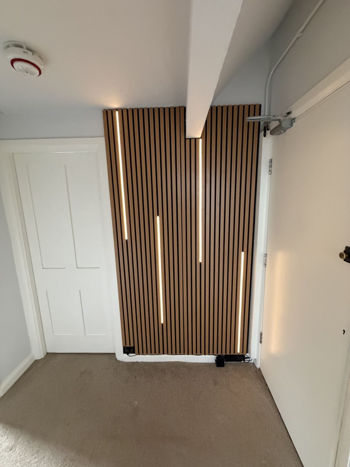 Slatted oak acoustic panelling with integrated LED lighting installed by Hamilton Decorating, East Sussex
