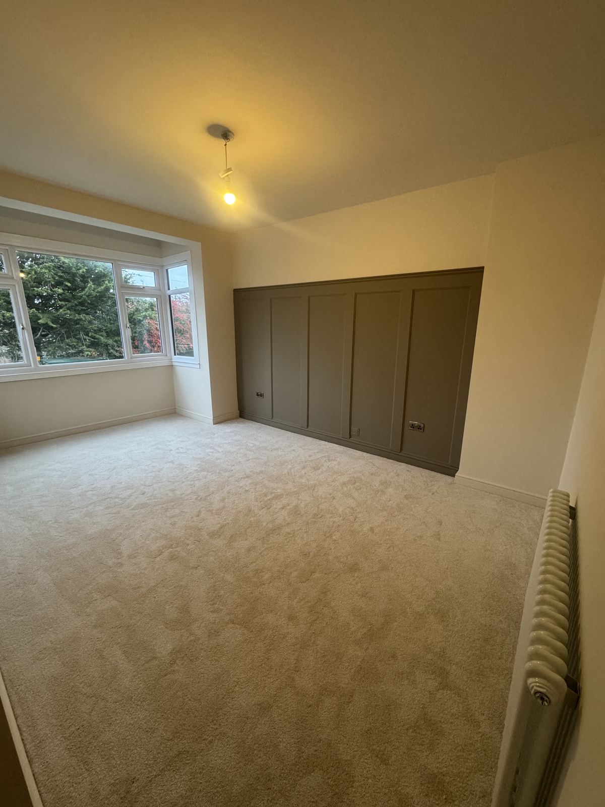 Built-in panelled wardrobe and feature wall in a bedroom, decorative panelling by Hamilton Decorating, East Sussex