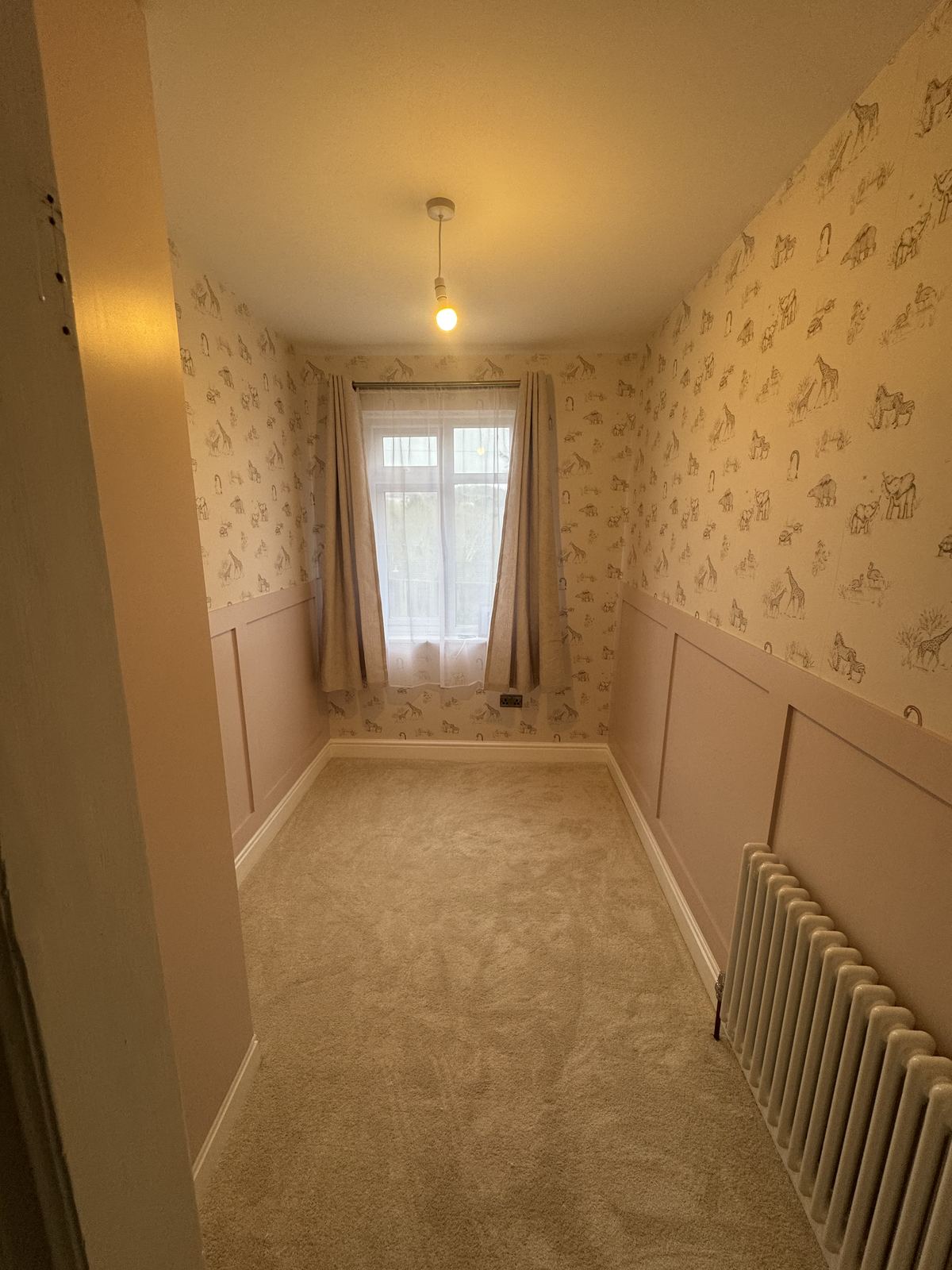Nursery with decorative wall panelling and giraffe wallpaper, fitted by Hamilton Decorating, East Sussex