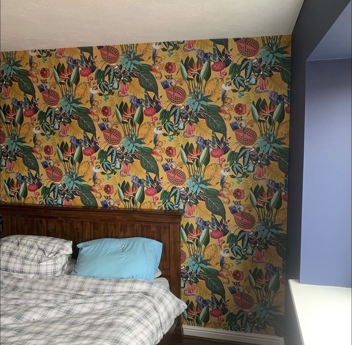 Bold tropical botanical wallpaper feature wall in a bedroom — wallpaper hanging by Hamilton Decorating, Hastings